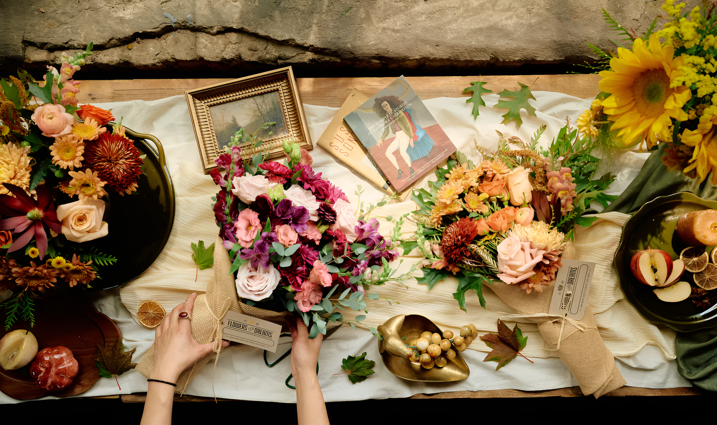 Autumn-inspired bouquets with red, orange, yellow, and purple blooms from Flowers for Dreams on a festive workshop table setting.