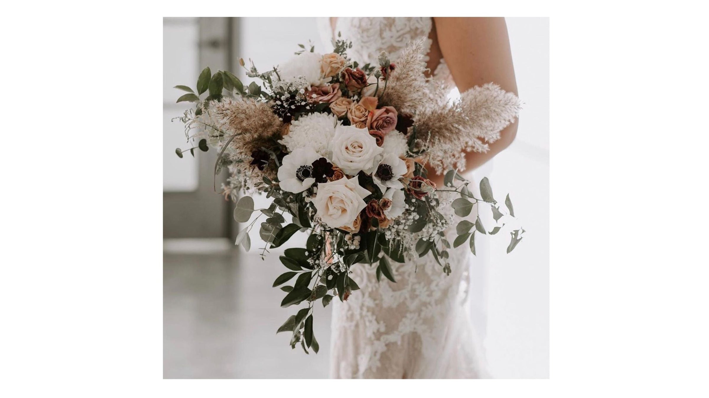 A bouquet of white roses, anemone, with lush pampas grass, foliage and dried elements, held by a bride from Flowers for Dreams.