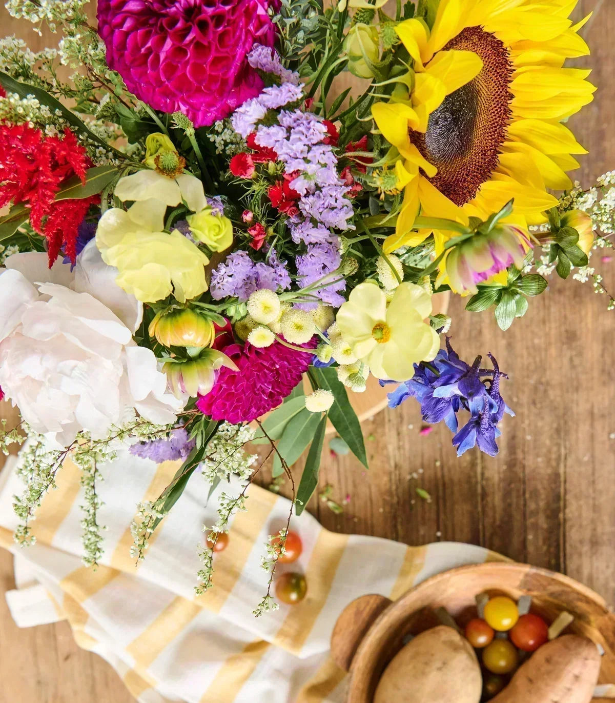 Lush late-summer bouquet featuring colorful seasonal blooms arranged in a clear glass vase.