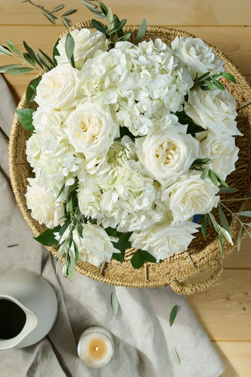 White roses and hydrangeas arranged in a soft, organic sympathy bouquet, locally crafted by Flowers for Dreams.