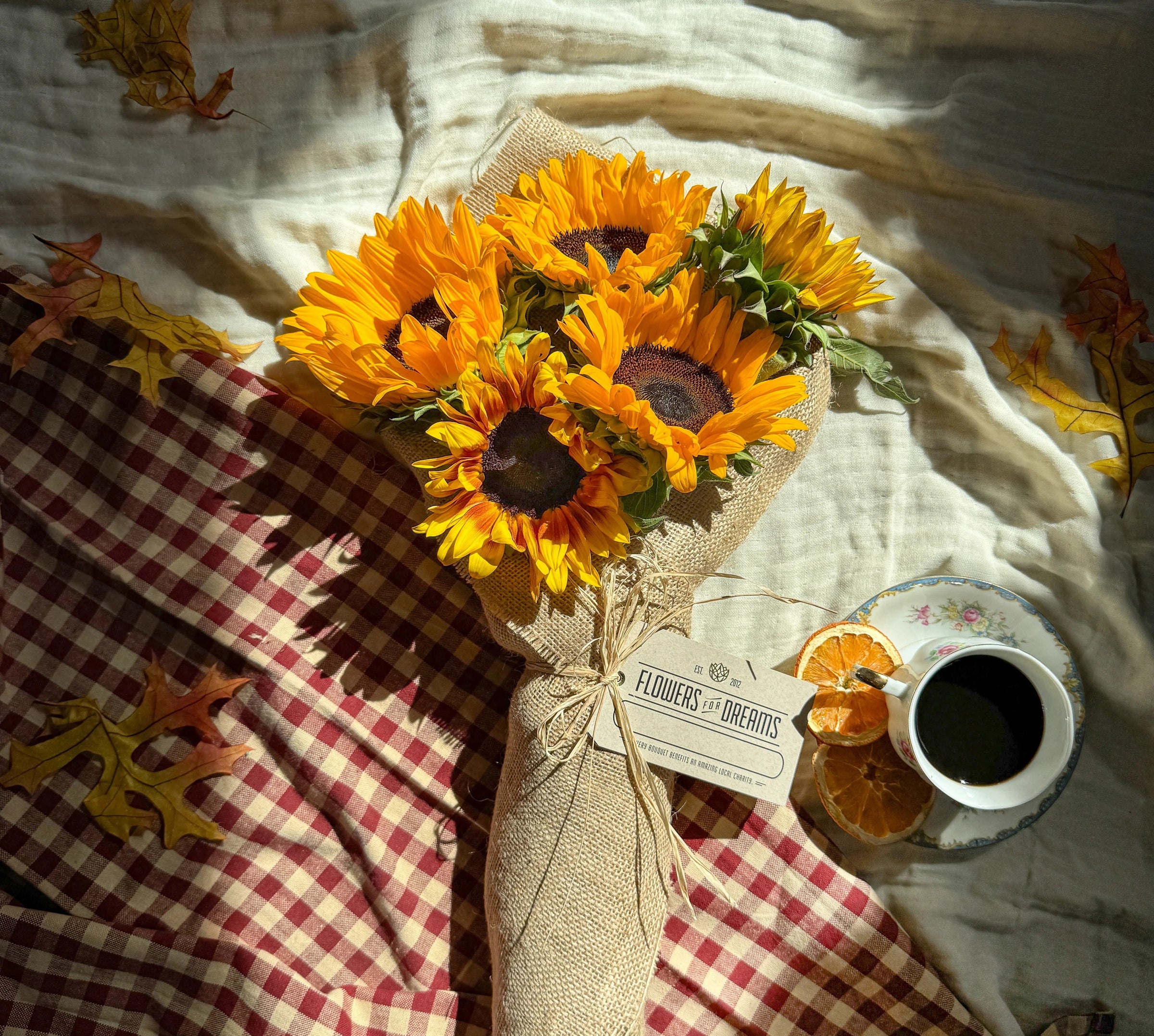 Overhead view of a vibrant sunflower bouquet from Flower for Dreams, wrapped in burlap, for a bright birthday special.