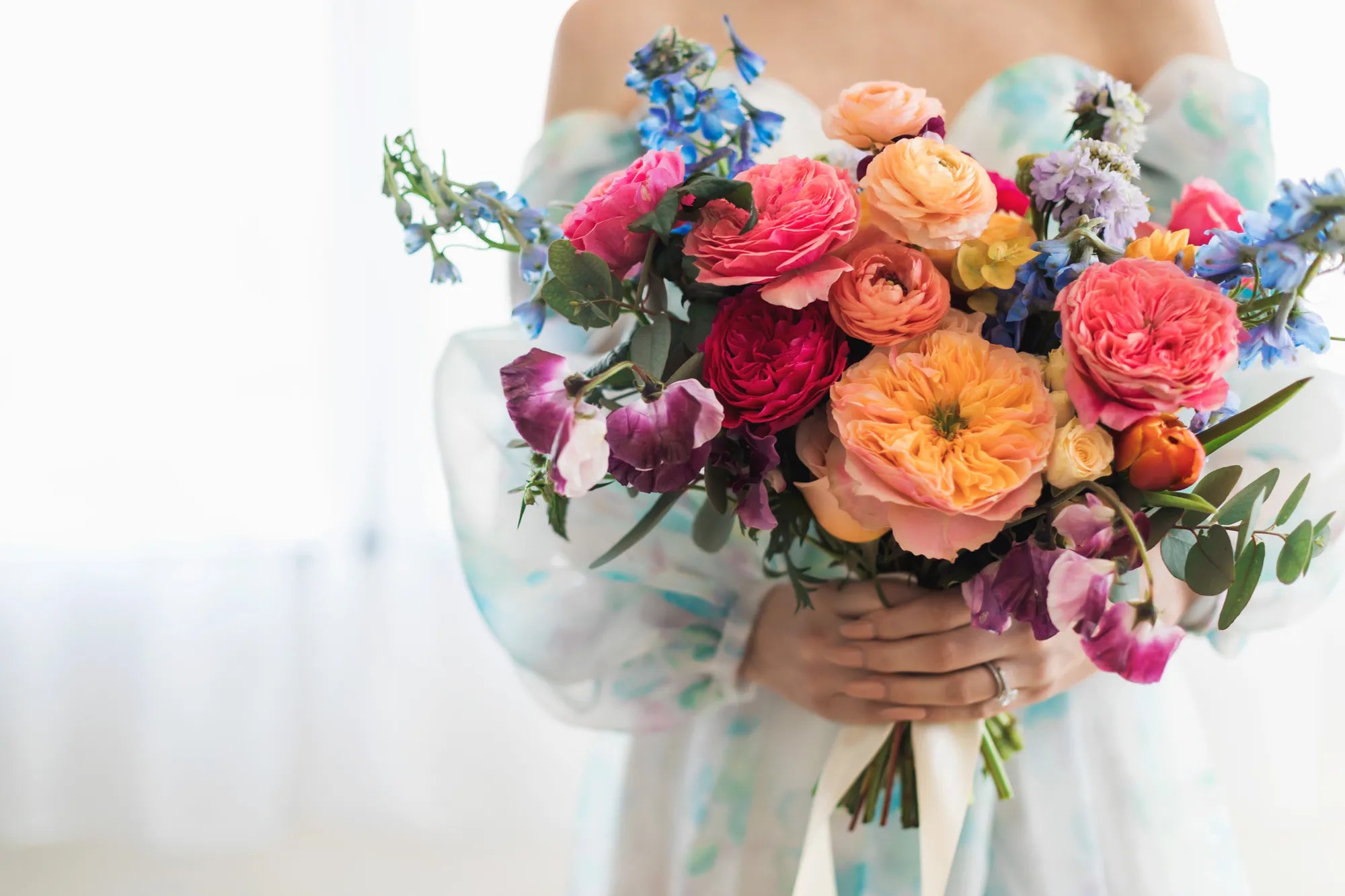 Bride holding a soft pastel spring wedding bouquet by Flowers for Dreams featuring seasonal blooms and airy floral textures.